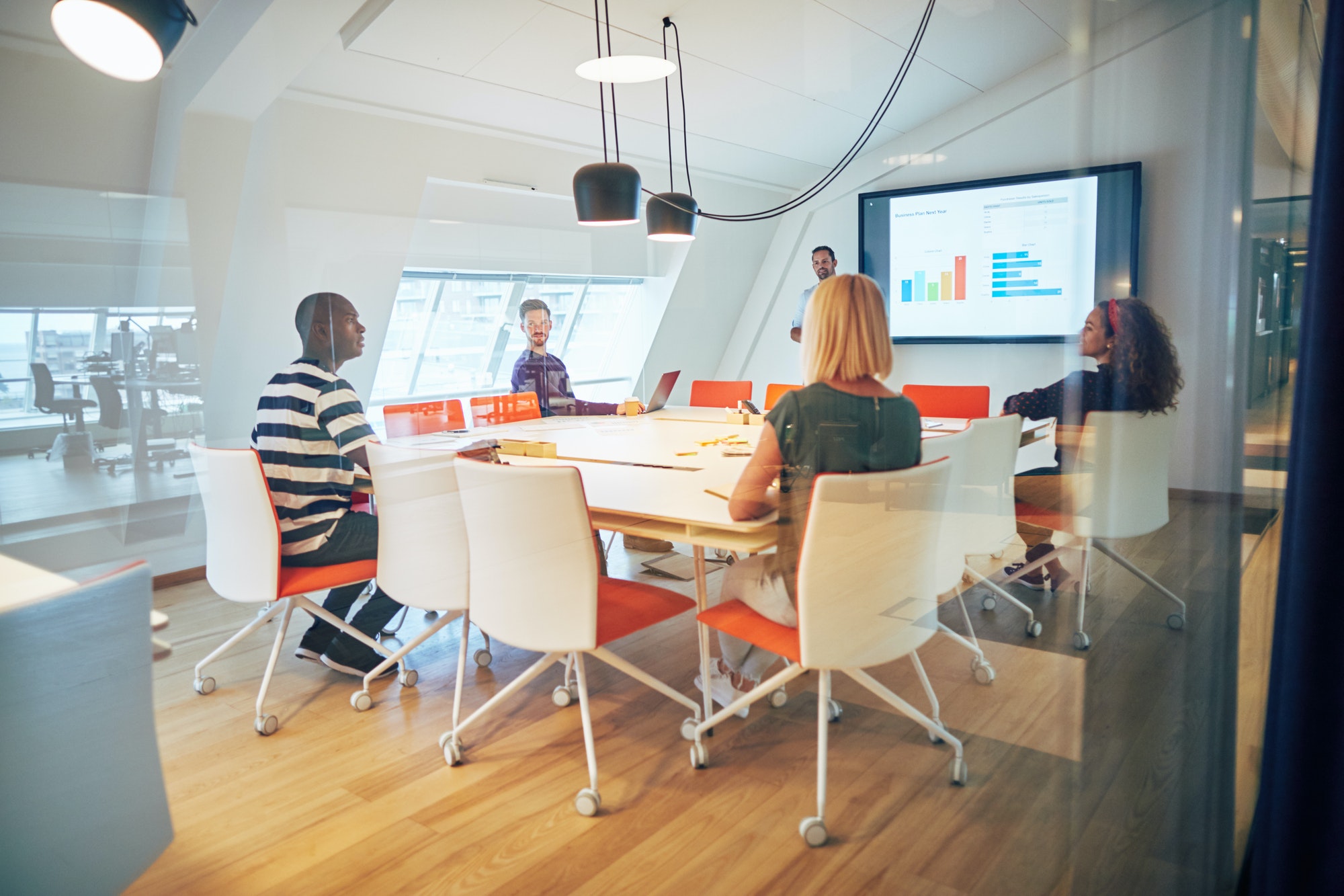 Group of diverse colleagues talking together during an office presentation