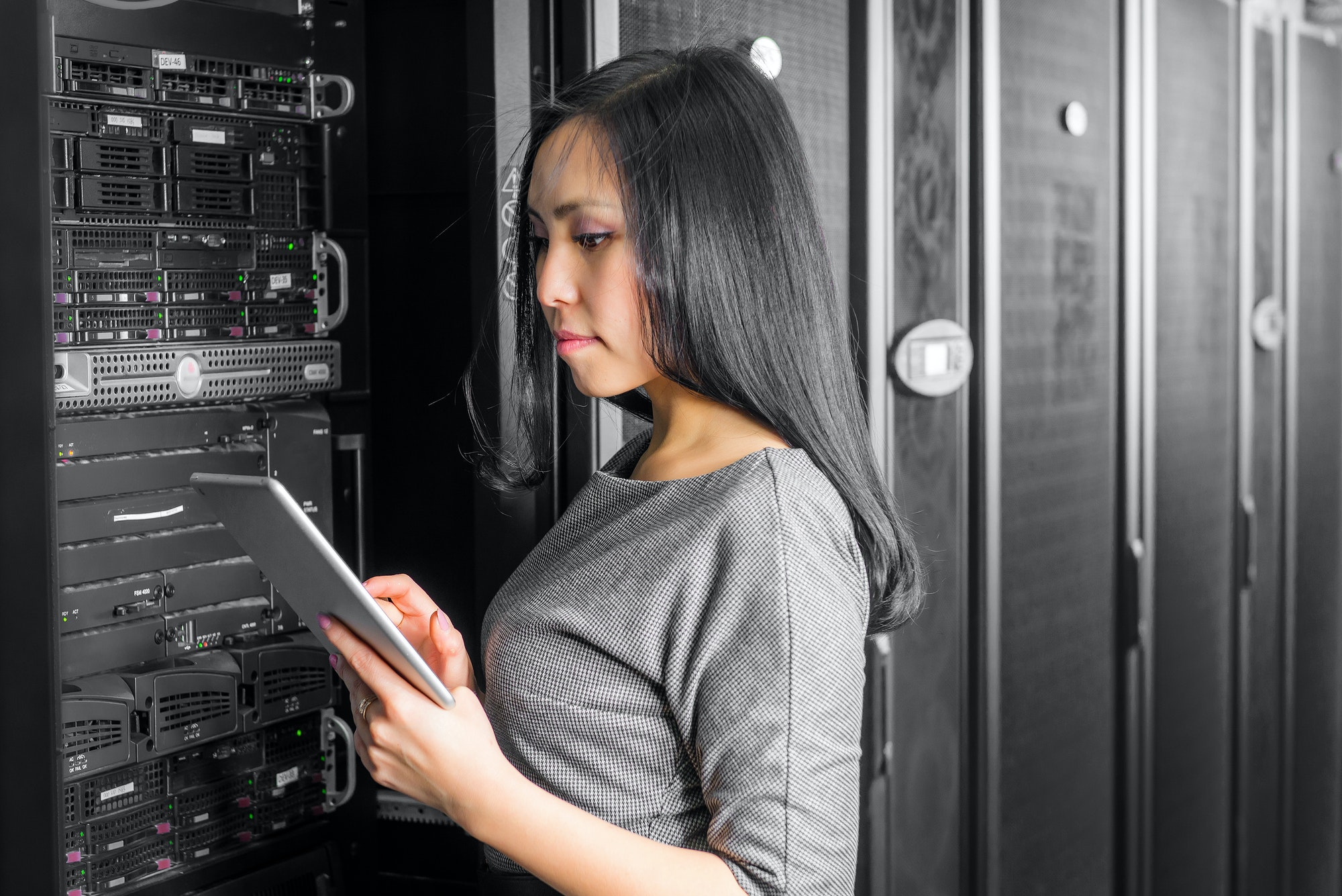 Young engineer businesswoman with tablet in network server room